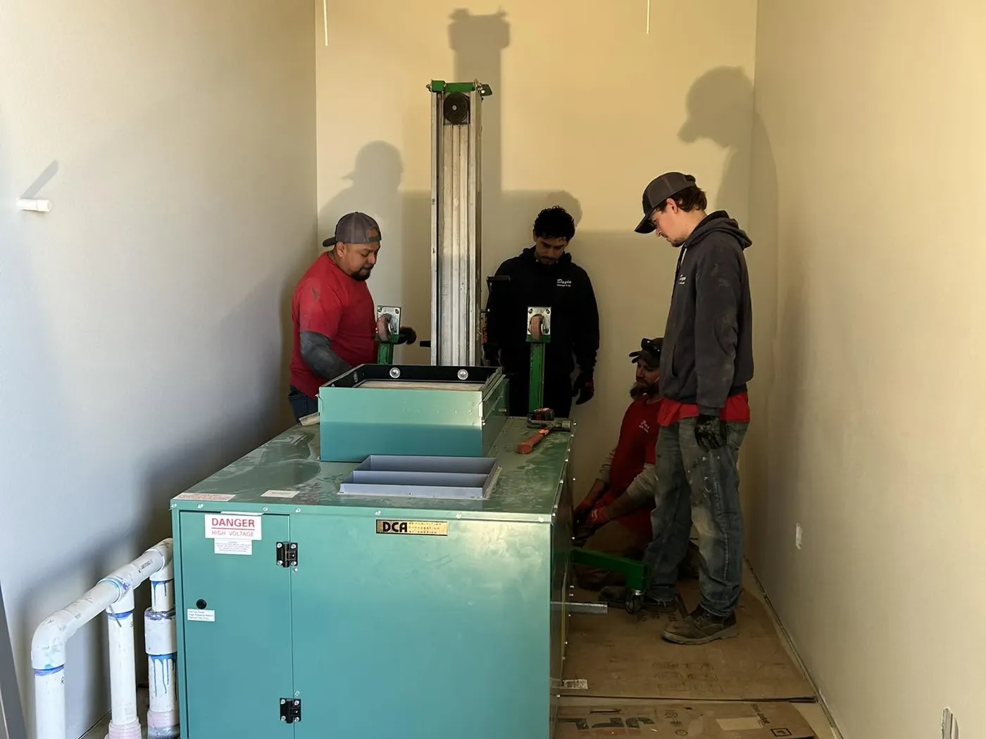 Dayco crew installing equipment in an unfinished commercial interior