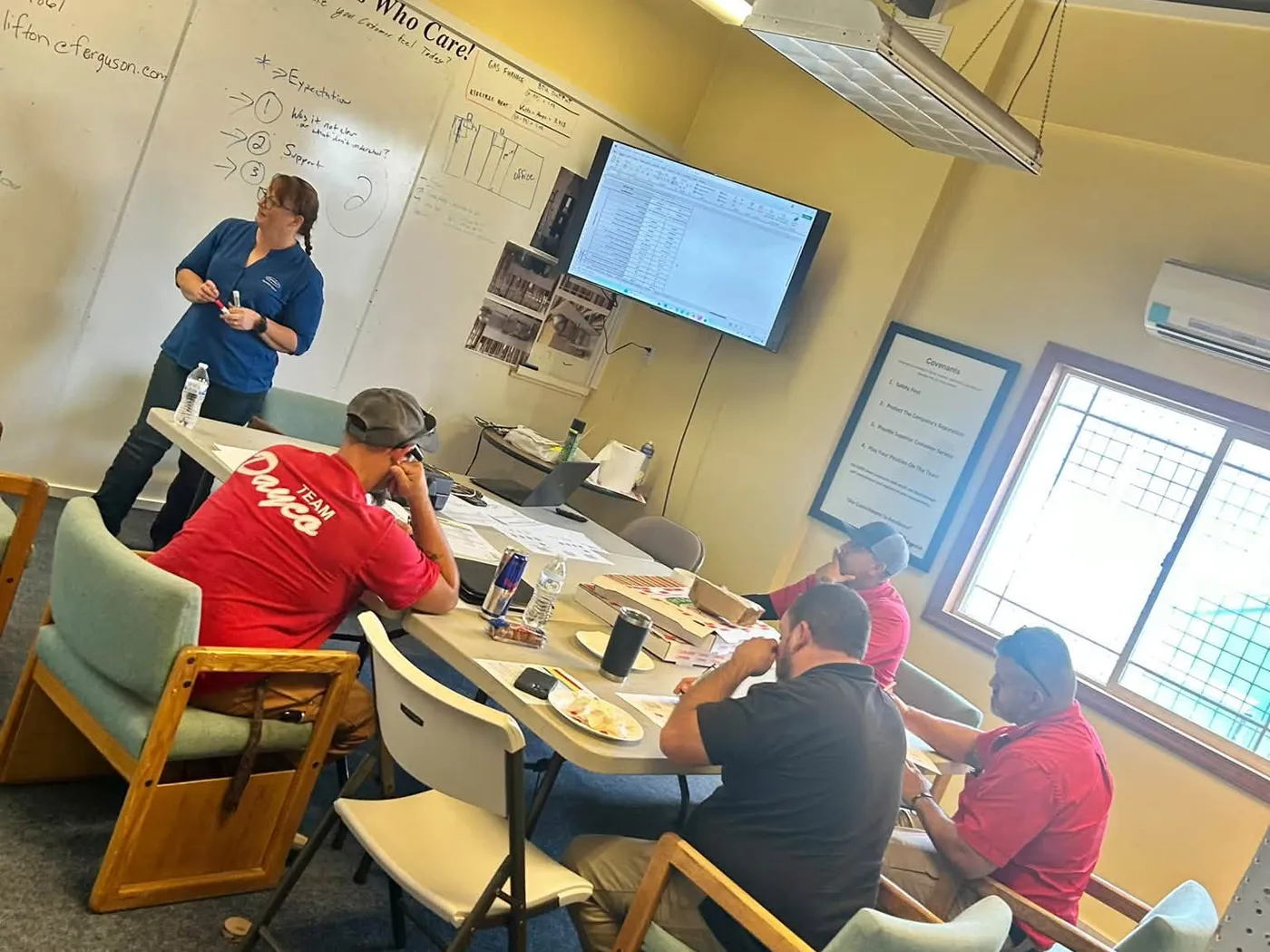 Dayco team members in red company shirts at a training session in the shop’s meeting room