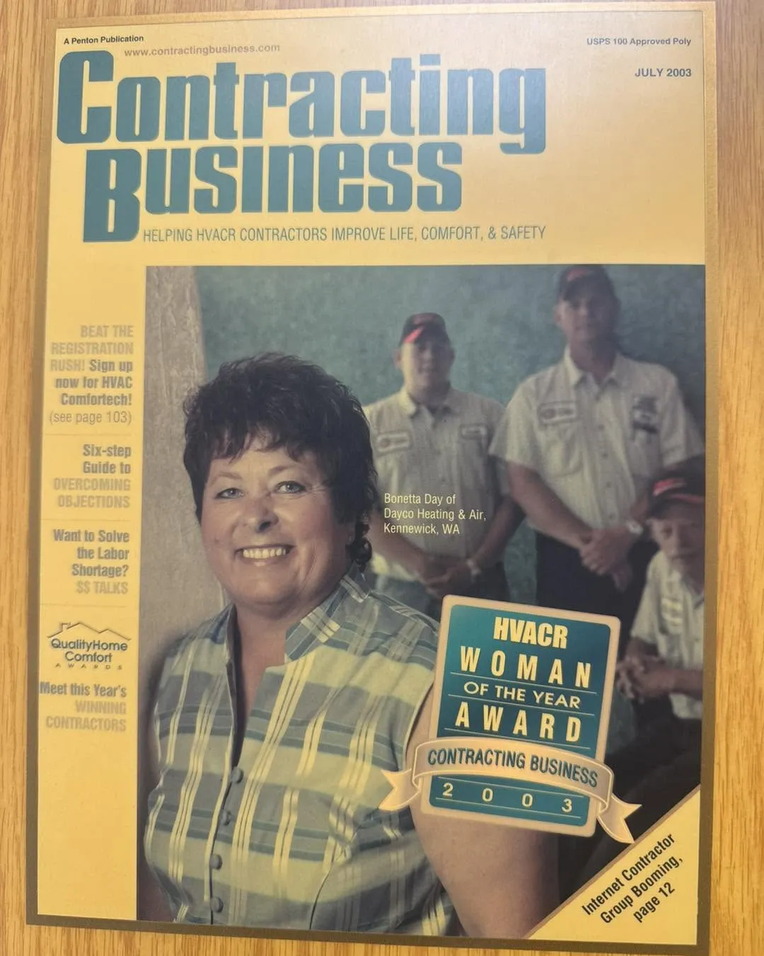 Framed Contracting Business magazine cover from July 2003 showing Bonetta Day of Dayco Heating & Air, Kennewick, smiling in front of three technicians, with an “HVACR Woman of the Year Award 2003” badge