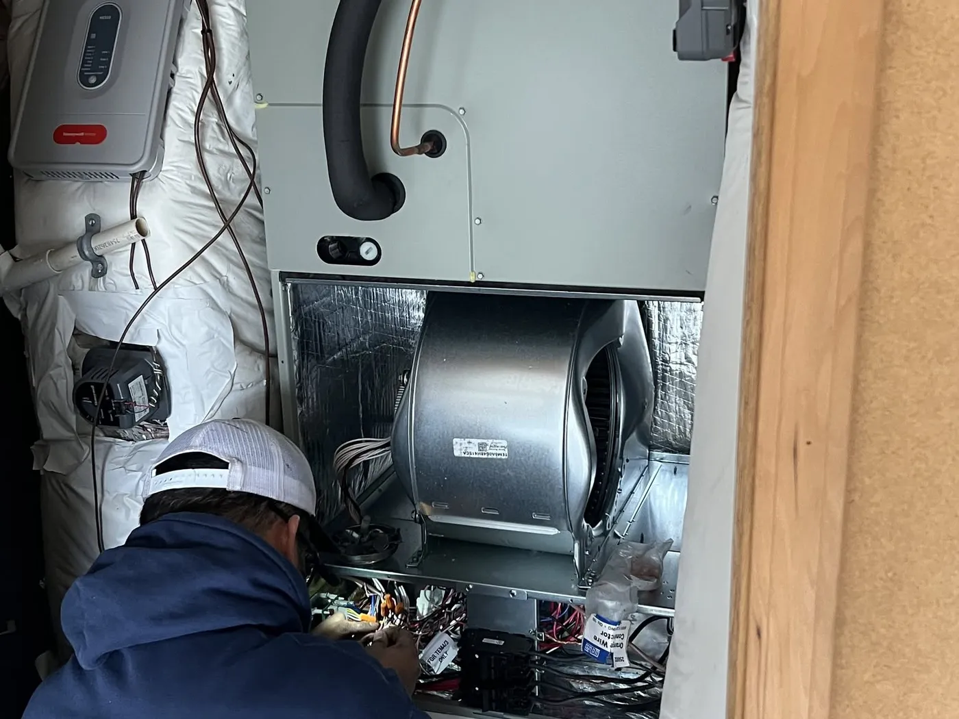 A Dayco technician working on indoor heat pump equipment